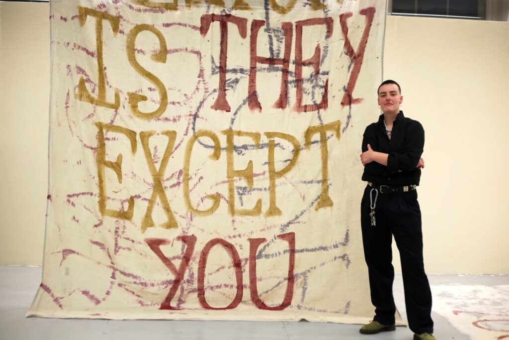 Artist George Storm Fletcher with a large scale text based artwork